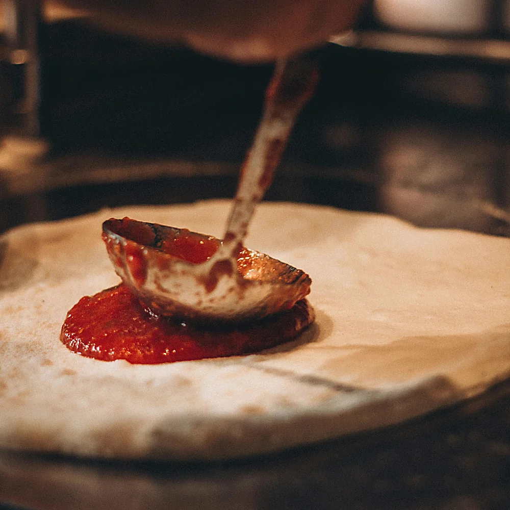 Stesura del pomodoro sulla base della pizza